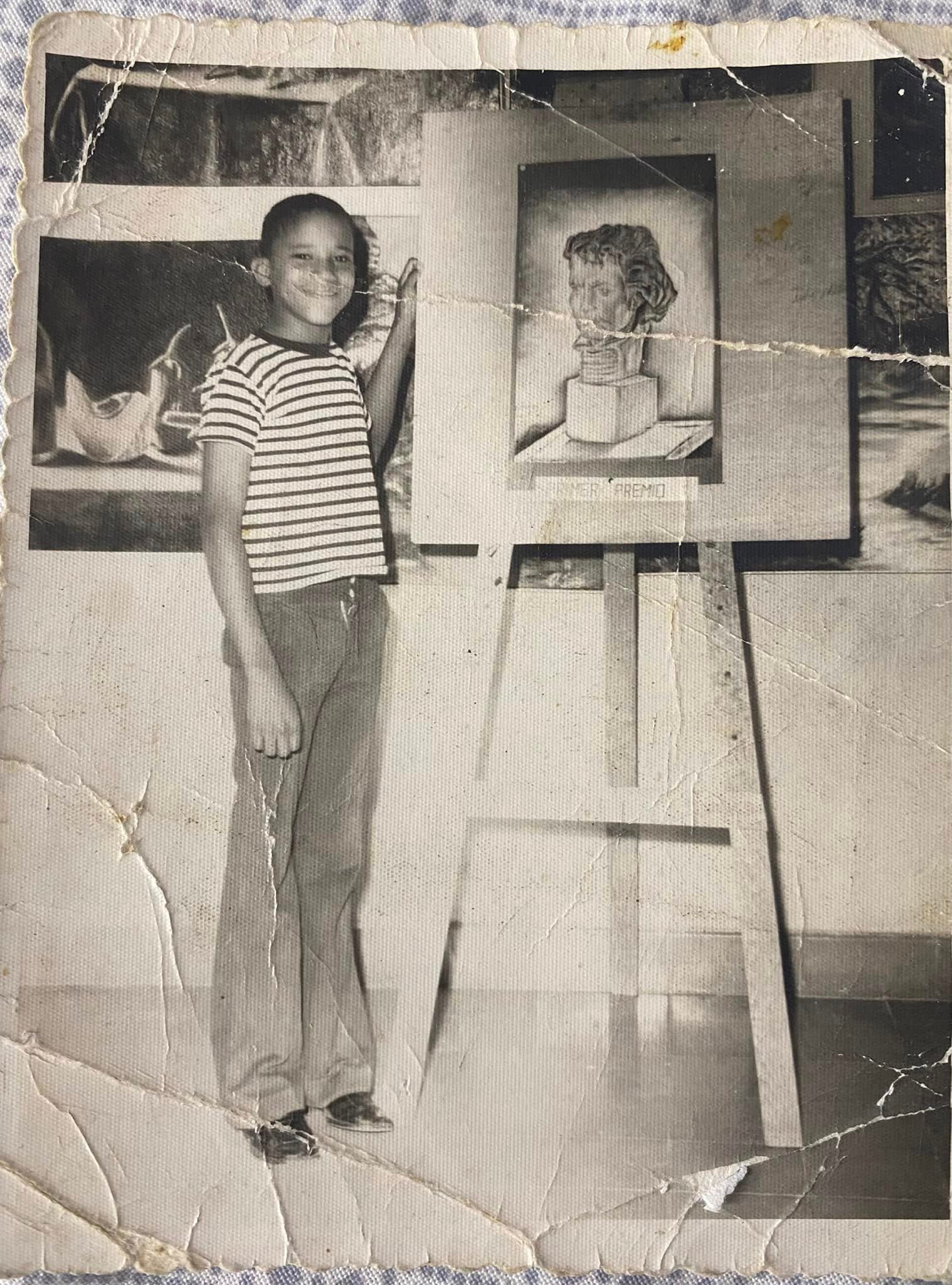 Ramon Alcantara as a young child standing beside artwork